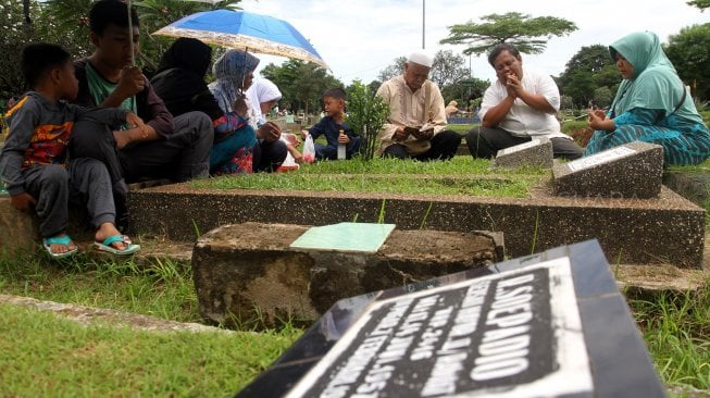 Warga berziarah kubur di Tempat Pemakaman Umum Karet Tengsin, Jakarta, Rabu (1/5). [Suara.com/Arief Hermawan P]
