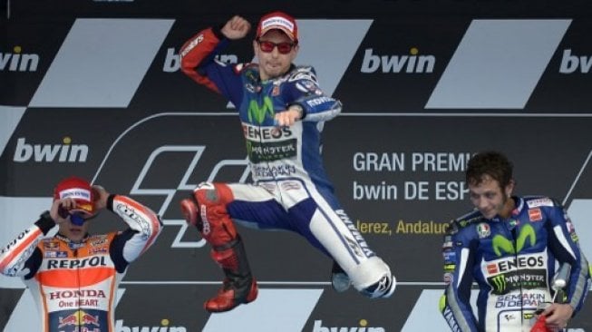 Jorge Lorenzo (tengah) meloncat kegirangan usai menjuarai MotoGP Spanyol 2015 di Sirkuit Jerez, Minggu (3/5). Diikuti kemudian oleh Marc Marquez (kiri) yang kini jadi rekan setimnya di Repsol Honda dan mantan partnernya di tim Movistar Yamaha, Valentino Rossi. [AFP/Jorge Guerrero]