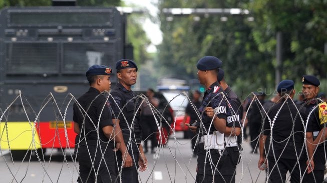 Aparat Kepolisian dilengkapi kendaraan taktis berjaga di kawasan Monas, Jakarta, Rabu (1/5). [Suara.com/Arief Hermawan p]