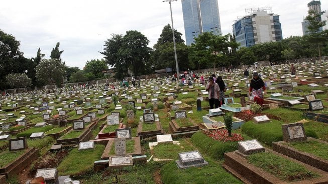 Warga berziarah kubur di Tempat Pemakaman Umum Karet Tengsin, Jakarta, Rabu (1/5). [Suara.com/Arief Hermawan P]
