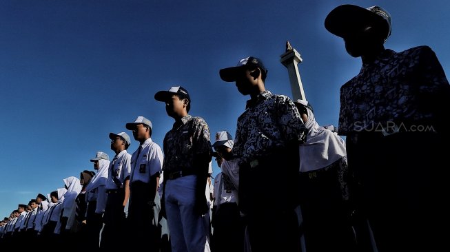 Sejumlah siswa mengikuti upacara bendera peringatan Hari Pendidikan Nasional di Lapangan Silang Monas, Jakarta, Kamis (2/5). [Suara.com/Muhaimin A Untung]