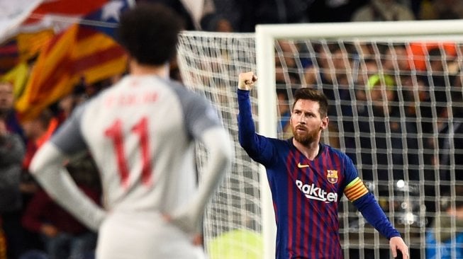 Megabintang sekaligus kapten Barcelona, Lionel Messi merayakan gol di depan penyerang Liverpool, Mohamed Salah dalam laga leg pertama semifinal Liga Champions 2018/2019 di Camp Nou, Kamis (2/5/2019) dini hari WIB. [Josep LAGO / AFP]