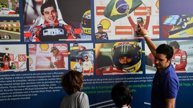 Para penggemar mengajak generasi di bawahnya untuk menyimak pameran Senna Day Festival yang digelar pada 1 Mei 2019 di Sirkuit Interlagos, Sao Paulo, sebagai bagian dari 25 tahun peringatan wafatnya juara dunia asal Brasil, Ayrton Senna da Silva [AFP/Nelson Almeida].