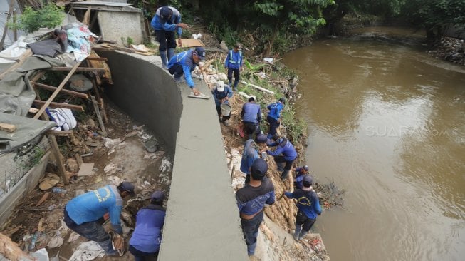 Sejumlah pasukan Sumber Daya Air DKI Jakarta memperbaiki tanggul sungai Ciliwung, Jakarta, Jumat (3/5).[Suara.com/Muhaimin A Untung]