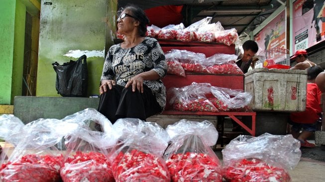 Pedagang merapihkan bunga di Pasar Rawa Belong, Jakarta, Jumat (3/5). [Suara.com/Arief Hermawan P]
