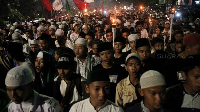 Warga Bogor mengikuti pawai obor di Jalan Raya Pajajaran, Kota Bogor, Jawa Barat, Jumat (3/5). [Suara.com/Arief Hermawan P]