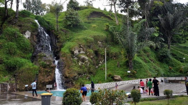 Pengunjung menikmati wisata air terjun yang dirancang dengan kolam renang di desa Parsaoran Sibisa, Kabupaten Toba Samosir, Sumatera Utara, Sabtu (4/5). ANTARA FOTO/Septianda Perdana