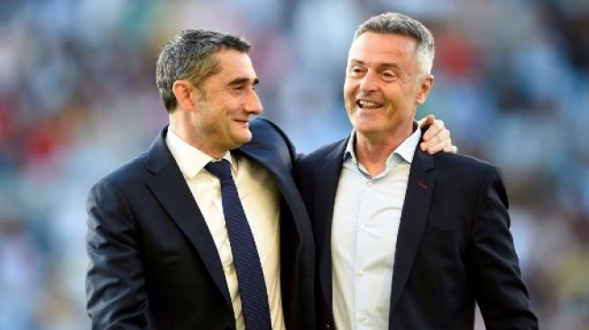 Pelatih Barcleona Ernesto Valverde (kiri) bercengkerama dengan Pelatih Celta Vigo, Fran Escriba, sebelum pertandingan pekan ke-36 La Liga Spanyol di Abanca-Balaidos dimulai pada, Minggu (5/5/2019) dini hari WIB. [AFP/Miguel Riopa]