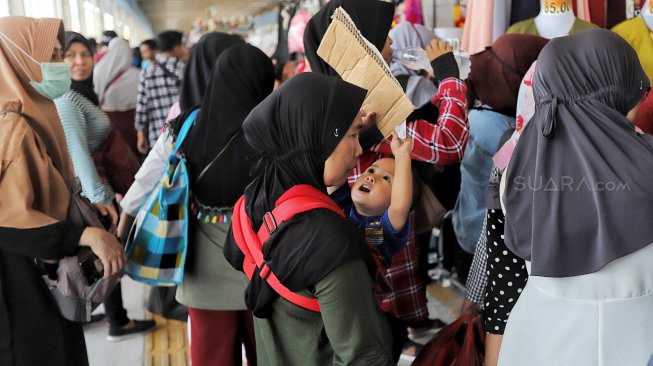 Pengunjung memadati "Skybridge" Pasar Tanah Abang, Jakarta, Minggu (5/5). [Suara.com/Muhaimin A Untung]