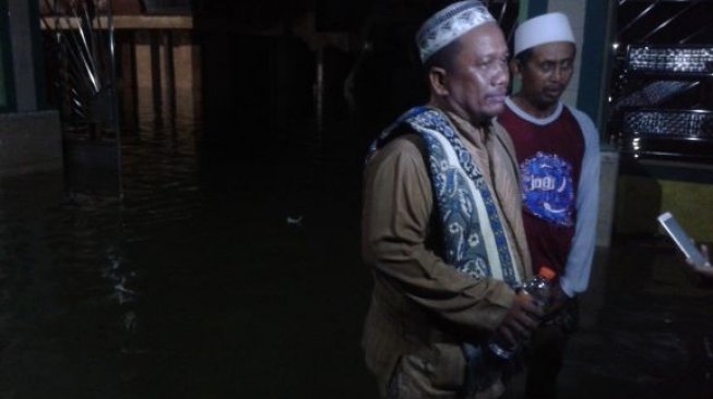 Warga Desa Tambak Beras yang terdampak Banjir Kali Lamong di Gresik Jawa Timur melangkahkan kaki ke masjid setempat untuk menunaikan Salat Tarawih. [Suara.com/Tofan Kumara]