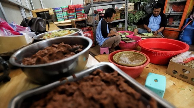 Sejumlah warga memasak lauk-pauk yang akan menjadi menu buka puasa di Masjid Istiqlal, Jakarta, Selasa (7/5). [Suara.com/Muhaimin A Untung]