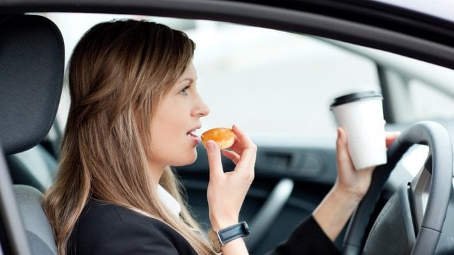 Minum dan makan di kabin kendaraan R4. Sebagai ilustrasi [Shutterstock].