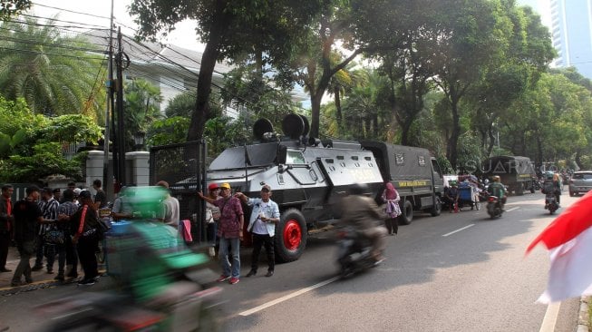 Sejumlah personel Kepolisian berjaga di sekitar kantor KPU yang dipasangi kawat berduri di Jalan Imam Bonjol, Jakarta, Kamis (9/5). [Suara.com/Arief Hermawan P]
