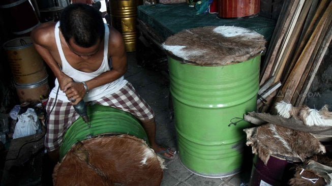 Perajin menyelesaikan pembuatan beduk di kawasan Tanah Abang, Jakarta Pusat,Kamis (9/5). [Suara.com/Oke Atmaja]
