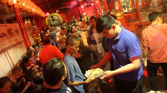 Warga Tionghoa menyajikan beragam menu buka puasa gratis untuk umat muslim ditengah guyuran hujan deras di Wihara Dharma Bakti alias Klenteng Kim Tek Ie, Jakarta, Kamis (8/5). [Suara.com/Arief Hermawan P]