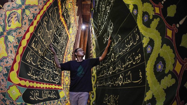 Perajin membentangkan batik motif ayat Al Quran yang dibuat di atas lembar kain di Mahkota Batik Laweyan, Solo, Jawa Tengah, Kamis (9/5). [ANTARA FOTO/Maulana Surya]