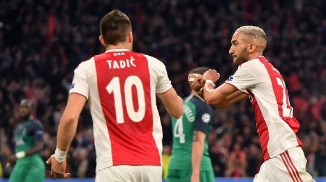 Gelandang Ajax Hakim Ziyech (kanan) merayakan golnya ke gawang Tottenham Hotspur di leg kedua semifinal Liga Champions. EMMANUEL DUNAND / AFP