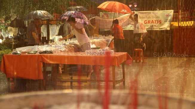 Warga Tionghoa menyajikan beragam menu buka puasa gratis untuk umat muslim ditengah guyuran hujan deras di Wihara Dharma Bakti alias Klenteng Kim Tek Ie, Jakarta, Kamis (8/5). [Suara.com/Arief Hermawan P]
