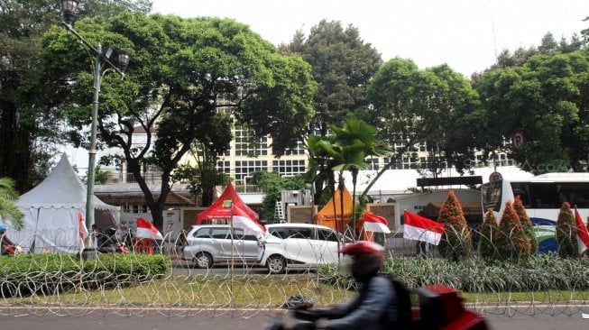 Sejumlah personel Kepolisian berjaga di sekitar kantor KPU yang dipasangi kawat berduri di Jalan Imam Bonjol, Jakarta, Kamis (9/5). [Suara.com/Arief Hermawan P]
