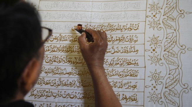 Perajin membuat batik motif ayat Al Quran di atas lembar kain di Mahkota Batik Laweyan, Solo, Jawa Tengah, Kamis (9/5). [ANTARA FOTO/Maulana Surya]