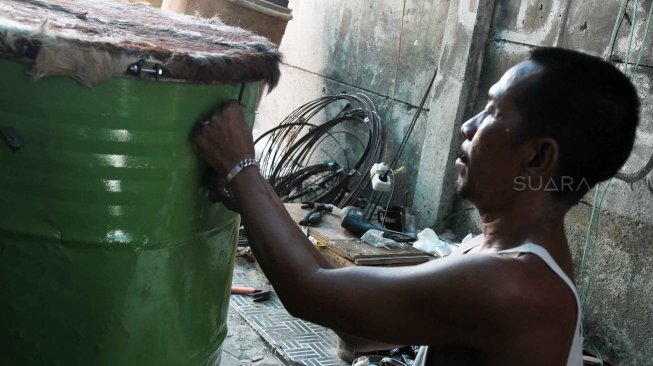 Perajin menyelesaikan pembuatan beduk di kawasan Tanah Abang, Jakarta Pusat,Kamis (9/5). [Suara.com/Oke Atmaja]
