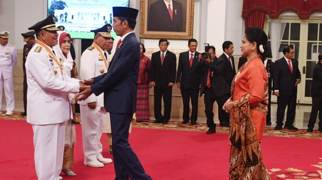 Presiden Joko Widodo (kedua kanan) disaksikan Ibu Negara Iriana Joko Widodo (kanan) memberi ucapan selamat kepada Gubernur Maluku Utara Abdul Gani Kasuba (kiri) dan Wakil Gubernur Al Yasin Ali seusai pelantikan di Istana Negara Jakarta, Jumat (10/5). ANTARA FOTO/Wahyu Putro A