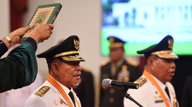 Gubernur Maluku Utara Abdul Gani Kasuba (kiri) dan Wakil Gubernur Al Yasin Ali mengikuti pelantikan yang dipimpin Presiden Joko Widodo di Istana Negara Jakarta, Jumat (10/5). ANTARA FOTO/Wahyu Putro A