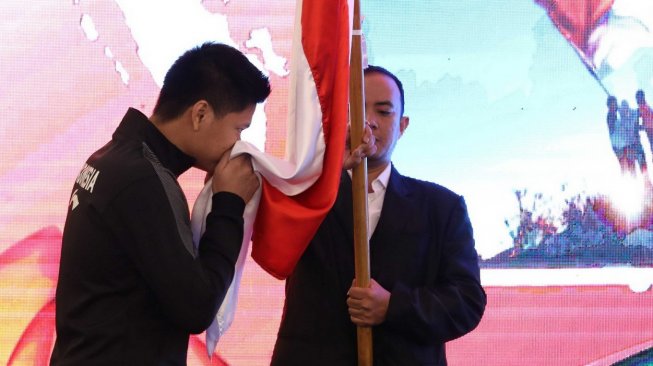 Pebulutangkis spesialis ganda campuran Indonesia, Praveen Jordan, mencium bendera Merah Putih dalam acara pelepasan Tim Indonesia di Piala Sudirman 2019. Acara ini berlangsung di Hotel Century, Senayan, Jakarta, Sabtu (11/5/2019). [Humas PBSI]