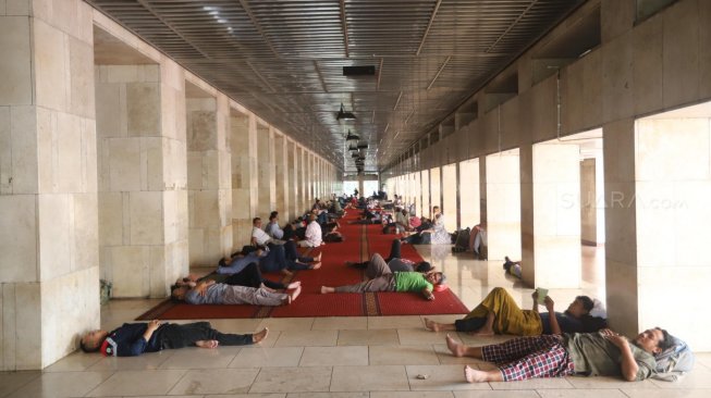 Jamaah saat melaksanakan tidur siang di ruang utama masjid Istiqlal, Jakarta Pusat, Sabtu (11/5). [Suara.com/Muhaimin A Untung]