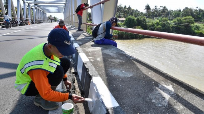 Pekerja mengecat marka jalan di Jembatan Jali Ketawang, Purworejo, Jawa Tengah, Jumat (10/5). ANTARA FOTO/Puspa Perwitasari