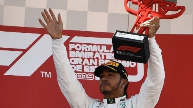 Pebalap Mercedes Lewis Hamilton merayakan kemenangannya di podium setelah memenangi F1 GP Spanyol di sirkuit de Catalunya. PIERRE-PHILIPPE MARCOU / AFP