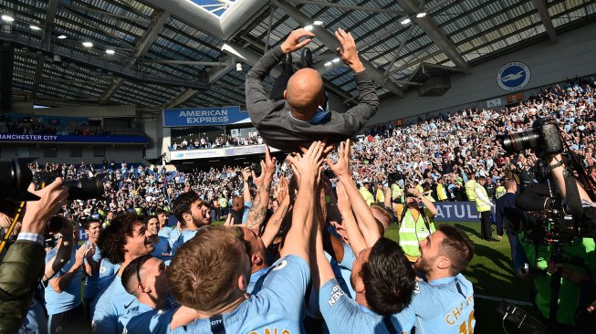 Manajer Manchester City Pep Guardiola merayakan gelar juara Liga Inggris 2018/2019 di American Express Community Stadium, Brighton, Inggris, Minggu (12/5). [Glyn KIRK / AFP]