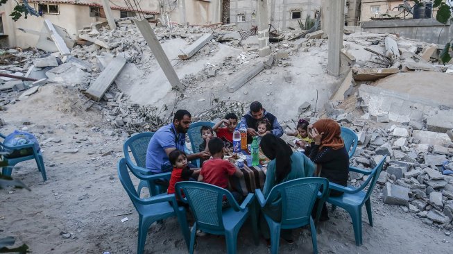 Warga Gaza berbuka puasa di rumah mereka yang hancur selama eskalasi dua hari, di Rafah, jalur Gaza Selatan. Rabu (8/5). [AFP Photo/Said Khatib]