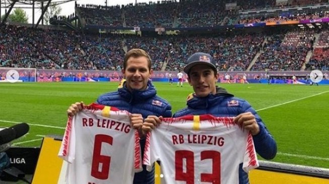 Juara dunia MotoGP 2018, Marc Marquez (kanan), dan pebalap penguji Repsol Honda, Stefan Bradl, memamerkan hadian jersey dari klub sepakbola RB Leipzig. [Instagram@hrc_motogp]