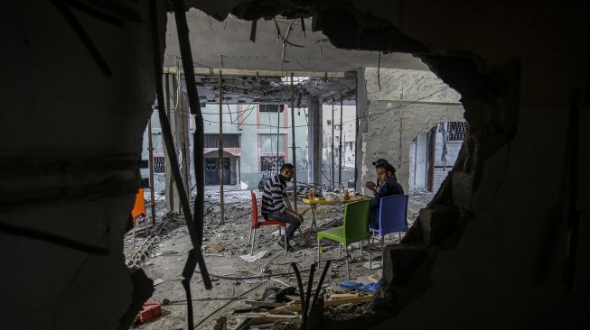 Warga Gaza berbuka puasa di rumah mereka yang hancur selama eskalasi dua hari, di Rafah, jalur Gaza Selatan. Rabu (8/5). [AFP Photo/Said Khatib]