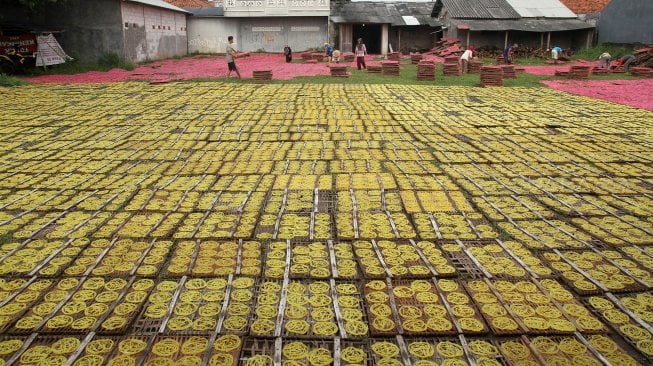 Pekerja menjemur kerupuk merah dan kerupuk mie mentah di kawasan Pasir Jambu, Karadenan, Kabupaten Bogor, Jawa Barat, Senin (13/5). [Suara.com/Arief Hermawan P]