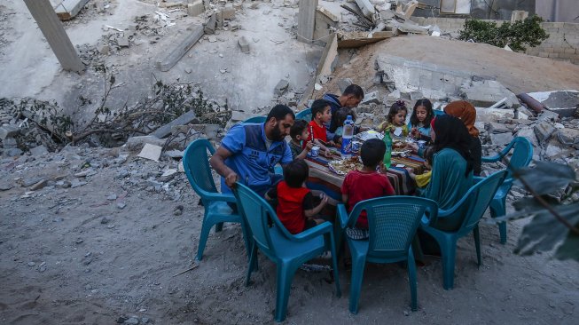 Warga Gaza berbuka puasa di rumah mereka yang hancur selama eskalasi dua hari, di Rafah, jalur Gaza Selatan. Rabu (8/5). [AFP Photo/Said Khatib]