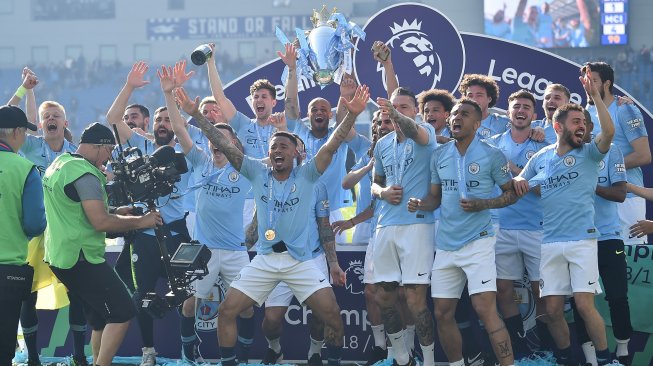 Para pemain Manchester City merayakan gelar juara Liga Inggris 2018/2019 di American Express Community Stadium, Brighton, Inggris, Minggu (12/5). [Glyn KIRK / AFP]