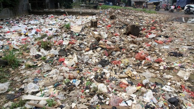 Kendaraan melintas di sekitar kali Baru yang dipenuhi sampah di Jalan Pabuaran, Bojonggede, Kabupaten Bogor, Jawa Barat, Selasa (14/5). [Suara.com/Arief Hermawan P]