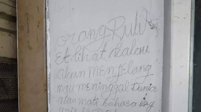 Tulisan di dinding dekat lokasi temuan potongan tubuh wanita. (istimewa).