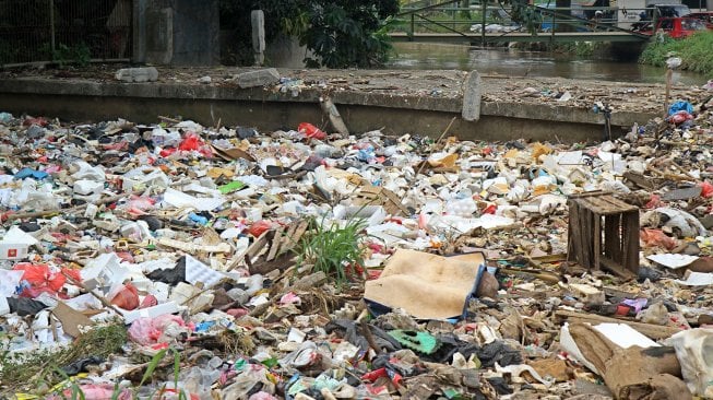 Kendaraan melintas di sekitar kali Baru yang dipenuhi sampah di Jalan Pabuaran, Bojonggede, Kabupaten Bogor, Jawa Barat, Selasa (14/5). [Suara.com/Arief Hermawan P]