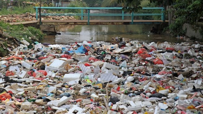 Kendaraan melintas di sekitar kali Baru yang dipenuhi sampah di Jalan Pabuaran, Bojonggede, Kabupaten Bogor, Jawa Barat, Selasa (14/5). [Suara.com/Arief Hermawan P]