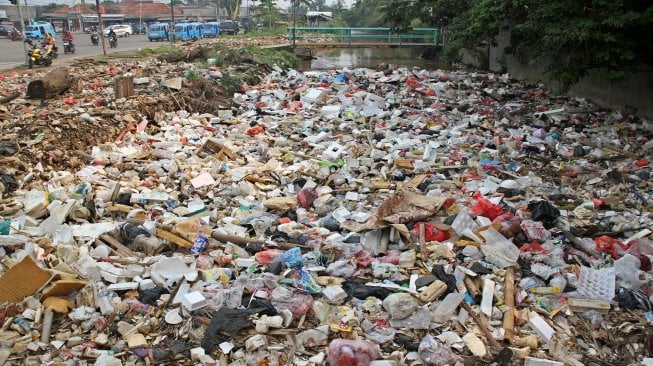 Kendaraan melintas di sekitar kali Baru yang dipenuhi sampah di Jalan Pabuaran, Bojonggede, Kabupaten Bogor, Jawa Barat, Selasa (14/5). [Suara.com/Arief Hermawan P]