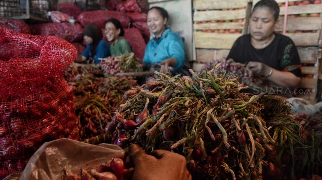 Pedagang merapihkan bawang merah di Pasar Induk Kramat Jati, Rabu (15/5). [Suara.com/Muhaimin A Untung]