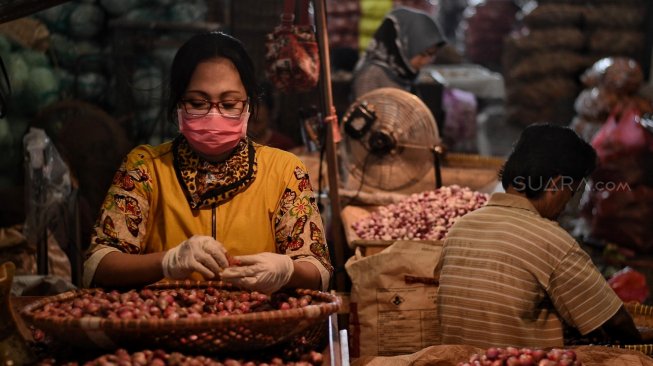 Pedagang merapihkan bawang merah di Pasar Induk Kramat Jati, Rabu (15/5). [Suara.com/Muhaimin A Untung]