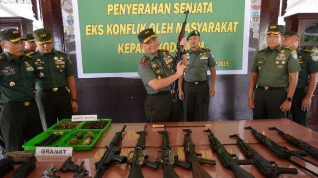 Panglima Kodam Iskandar Muda, Mayjen TNI Teguh Arief Indratmoko (tengah) memeriksa senjata laras panjang bekas konflik Aceh saat rilis kasus di Banda Aceh, Rabu (15/5). [ANTARA FOTO/Ampelsa]