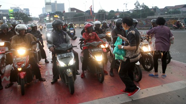 Sejumlah Relawan dari Forum Komunikasi dan Kerjasama Umat Kristiani Kota Depok (FKKUKD) membagikan takjil gratis kepada pengendara yang melintas di Jalan Margonda Raya, Depok, Rabu (15/5). [Suara.com/Arief Hermawan P]