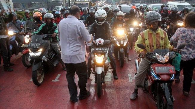 Sejumlah Relawan dari Forum Komunikasi dan Kerjasama Umat Kristiani Kota Depok (FKKUKD) membagikan takjil gratis kepada pengendara yang melintas di Jalan Margonda Raya, Depok, Rabu (15/5). [Suara.com/Arief Hermawan P]