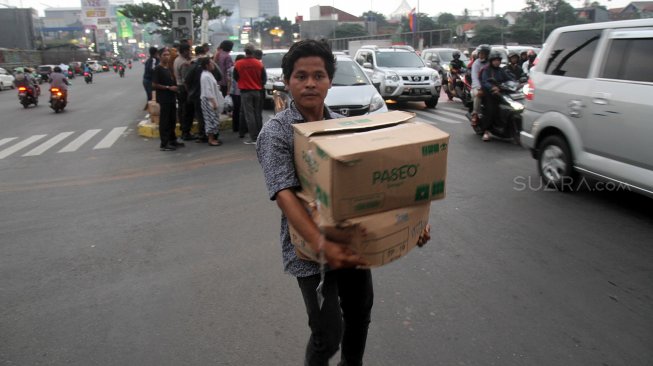 Sejumlah Relawan dari Forum Komunikasi dan Kerjasama Umat Kristiani Kota Depok (FKKUKD) membagikan takjil gratis kepada pengendara yang melintas di Jalan Margonda Raya, Depok, Rabu (15/5). [Suara.com/Arief Hermawan P]