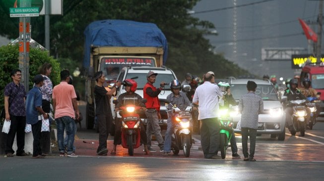 Sejumlah Relawan dari Forum Komunikasi dan Kerjasama Umat Kristiani Kota Depok (FKKUKD) membagikan takjil gratis kepada pengendara yang melintas di Jalan Margonda Raya, Depok, Rabu (15/5). [Suara.com/Arief Hermawan P]